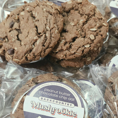 Several packaged chocolate chip cookies in clear plastic bags with round labels. The label reads 'Peanut butter chocolate chip cookie' with 'Backcountry' visible on the top label.